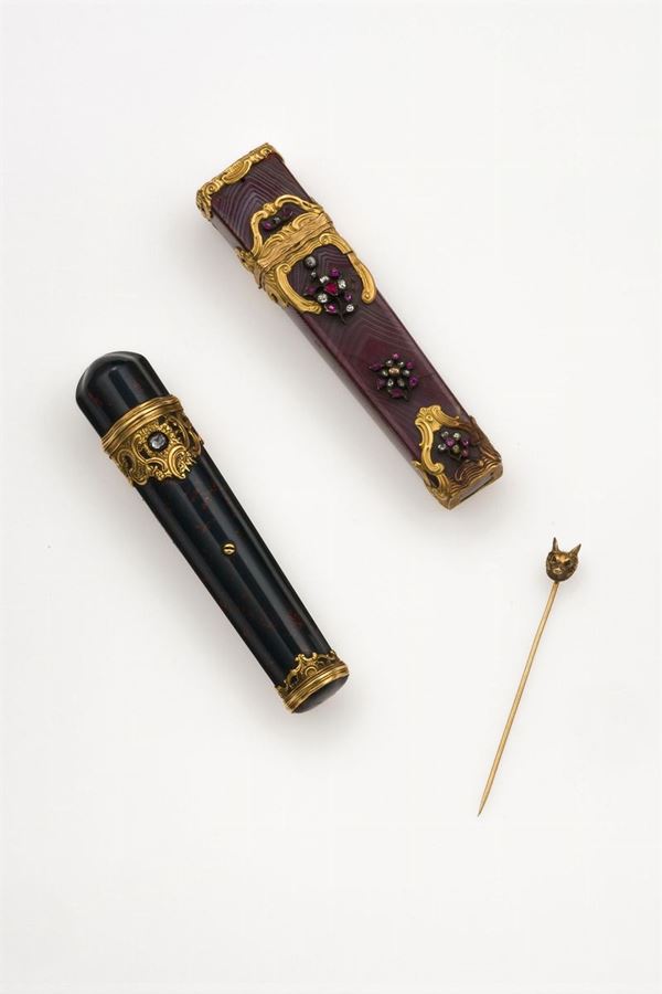 Two perfume bottles and one gold and emerald stickpin