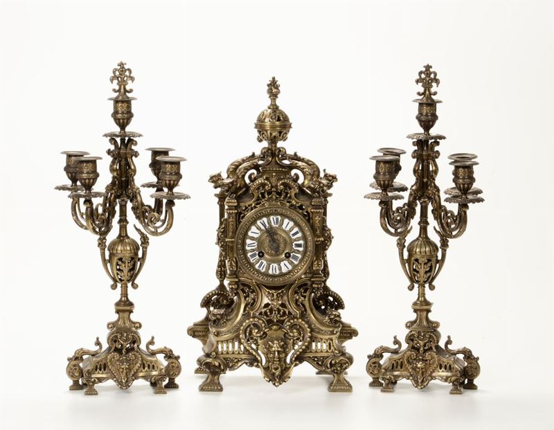Trittico da camino composto da pendola e coppia di candelabri in metallo argentato, XIX-XX secolo  - Auction Works of Art Timed Auction - IV - Cambi Casa d'Aste