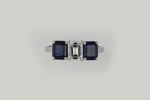 Anello con diamante centrale taglio smeraldo di ct 0,85 e zaffiri a contorno