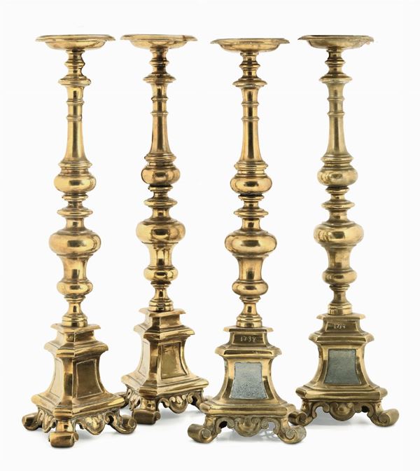 Gruppo di quattro candelieri torniti in bronzo dorato, datati 1738