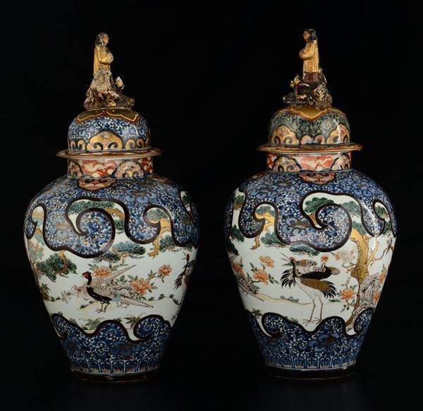 Coppia potiches in porcellana Arita con prese a foggia di personaggi e raffigurazioni naturalistiche, Giappone, periodo Edo, XVIII secolo