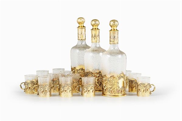 Servizio da rosolio composto da tre bottiglie e dieci bicchieri in vetro molato e argento dorato. Argenteria inglese d'importazione XX secolo