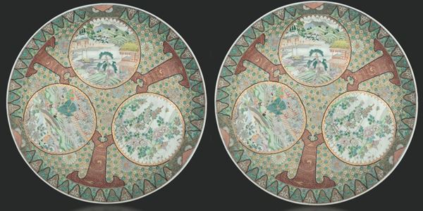 Coppia di grandi piatti in porcellana Imari con scene naturalistiche e di vita comune entro riserve, Giappone, XIX secolo