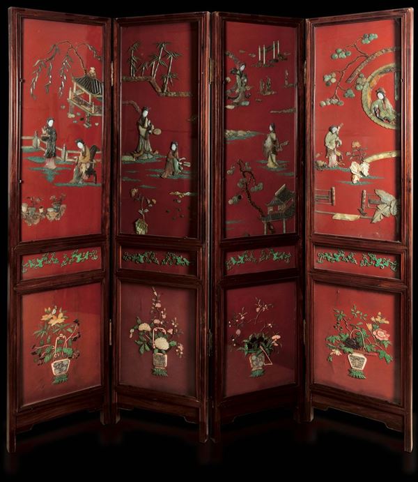 Grande paravento a quattro ante in legno laccato e applicazioni in pietre dure con scene di vita comune e decori floreali su fondo rosso, Cina, XIX secolo