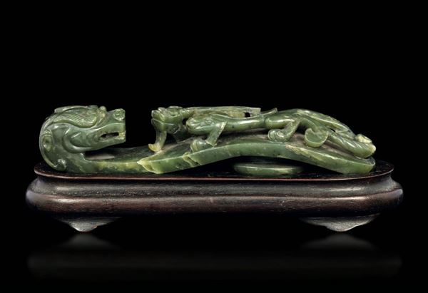Piccola fibbia scolpita in giada color spinacio con figura di draghetto a rilievo, Cina, Dinastia Qing, epoca Qianlong (1736-1796)