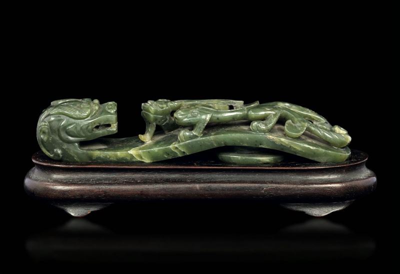 Piccola fibbia scolpita in giada color spinacio con figura di draghetto a rilievo, Cina, Dinastia Qing, epoca Qianlong (1736-1796)  - Asta Arte Orientale - Cambi Casa d'Aste