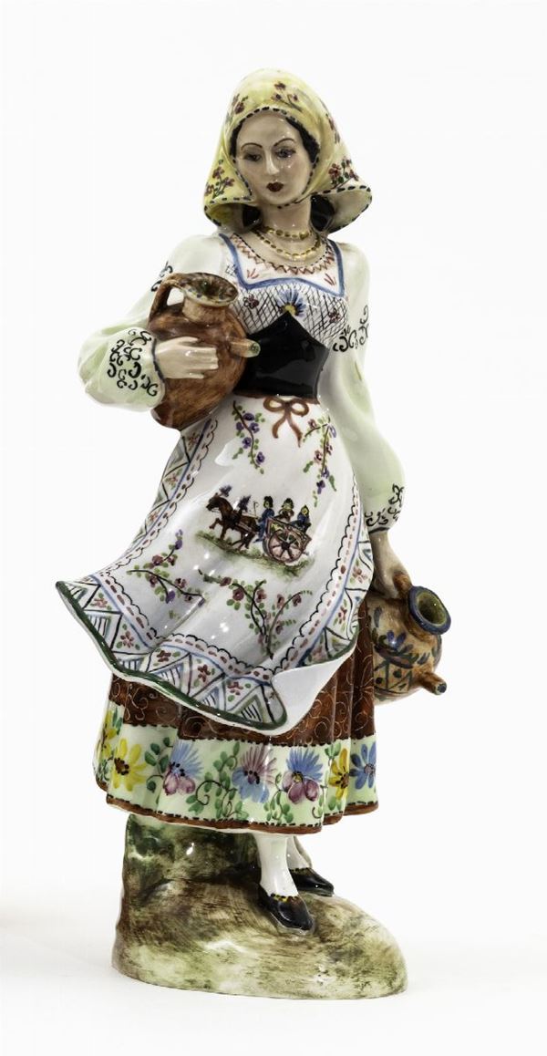 Figura femminile in tipico abito regionale in terraglia a colaggio con decori in policromia.  Altezza cm 34