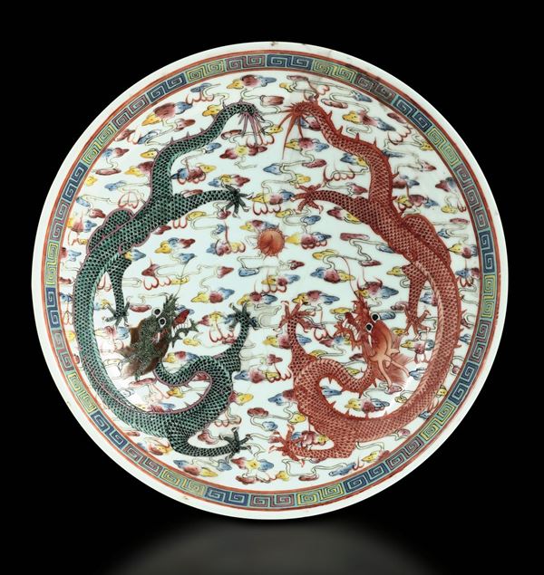 Lotto composto da due piatti in porcellana a smalti policromi con decoro di draghi tra le nuvole sui toni del rosso e del verde, Cina, Dinastia Qing, epoca  Guangxu (1875-1908)