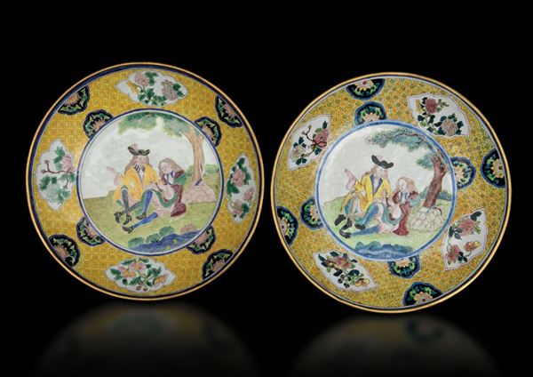 Rara coppia di piatti a smalti con raffigurazioni di gentiluomini e decoro floreale entro riserve da un disegno di Cornelis Prok, Cina, Dinastia Qing, epoca Qianlong (1736-1796)