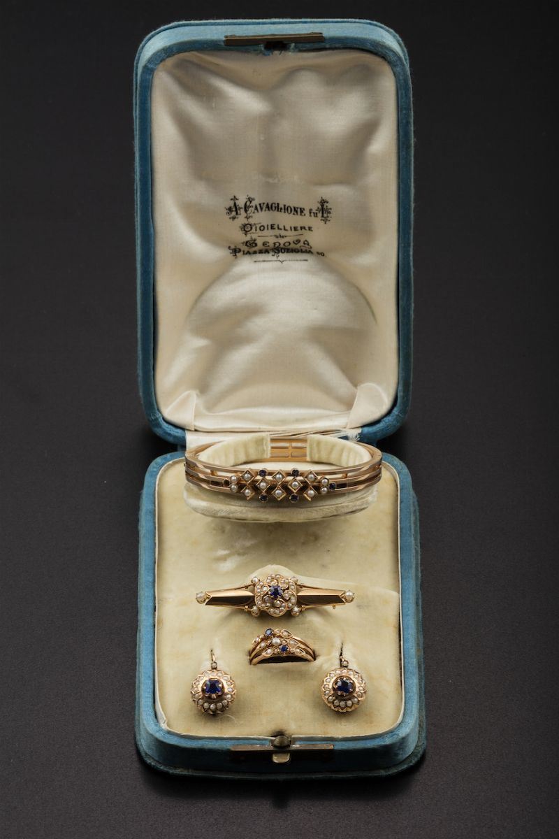 Parure composta da bracciale rigido, orecchini, spilla ed anello con piccole perle e vetri blu  - Asta Fine Coral Jewels - I - Cambi Casa d'Aste