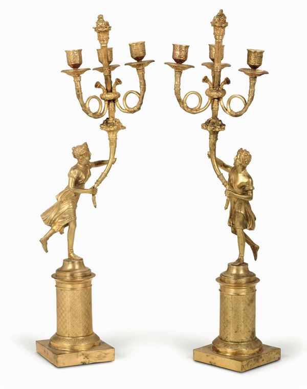 Coppia di candelabri a tre fiamme con figure in bronzo dorato e cesellato, XIX-XX secolo