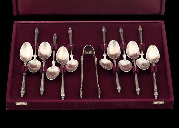 Set di cucchiaini e pinza per lo zucchero in argento fuso e cesellato, custodia in velluto, Francia XX secolo