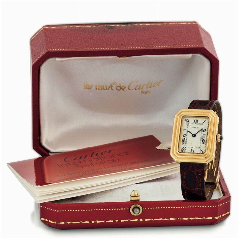 Cartier, Paris. Fine, rectangular, 18K yellow gold wristwatch with original gold deployant clasp. Acompanied by the original box, additional strap and Guarantee. Made circa 1970  - Auction wrist and pocket watches - Cambi Casa d'Aste
