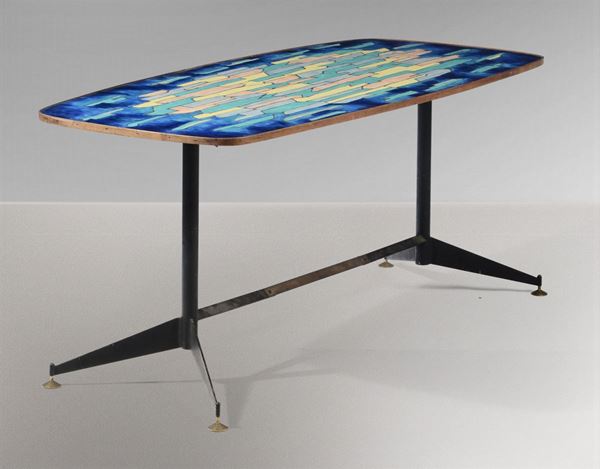 Tavolo con struttura in metallo laccato e sostegni in ottone. Piano in legno smaltato.