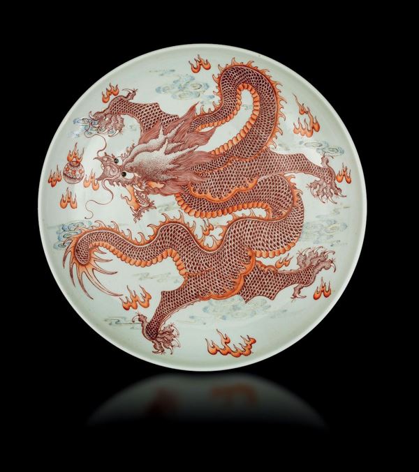 Grande piatto in porcellana a smalti policromi con figura di drago sui toni del rosso, Cina, XX secolo