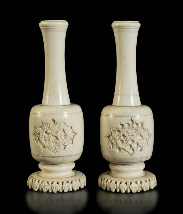 Coppia di piccoli vasi a bottiglia scolpiti in avorio con figure di draghi e base con motivo a foglioline, Cina, inizi XX secolo