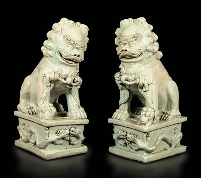 Coppia di Grandi Leoni in Porcellana Blanc De Chine su Basi Decorate con Figure di Draghi a Rilie...