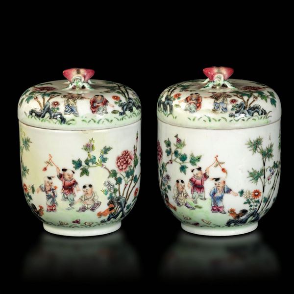 Coppia di piccoli vasi con coperchio in porcellana a smalti policromi con presa a foggia di pesche e raffigurazioni di bambini che giocano entro paesaggio, Cina, marchio e del periodo Guangxu (1875-1908)