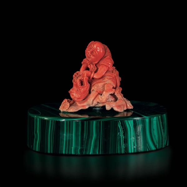 A carved coral group on a malachite base, China, early 1900s
