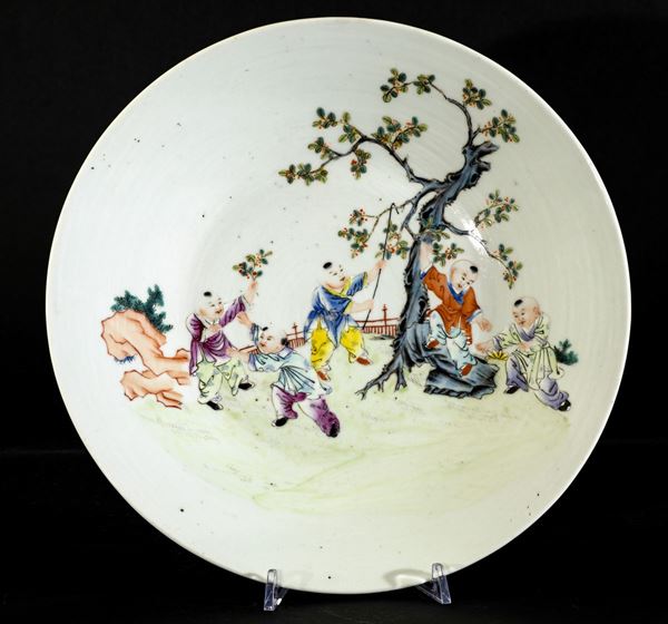 Piatto in porcellana a smalti policromi con raffigurazione di bambini che colgono frutti, Cina