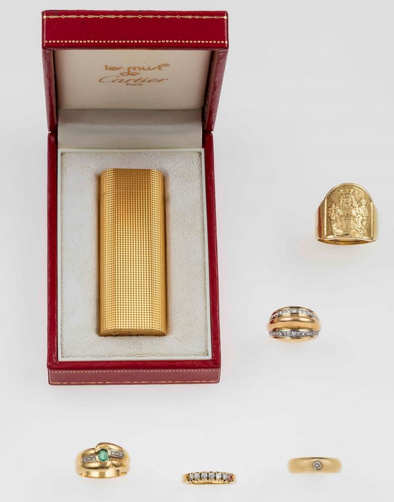 Lotto composto da un accendino Cartier placcato oro e cinque anelli con diamanti ed un piccolo smeraldo  - Asta Fine Jewels - II - Cambi Casa d'Aste