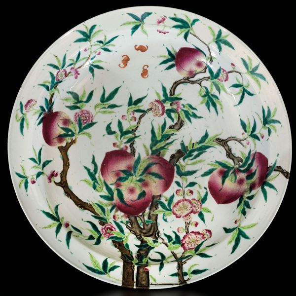 Grande piatto in porcellana a smalti policromi con decoro di pesche, fiori e pipistrelli, Cina, Dinastia Qing, epoca Guangxu (1875-1908)