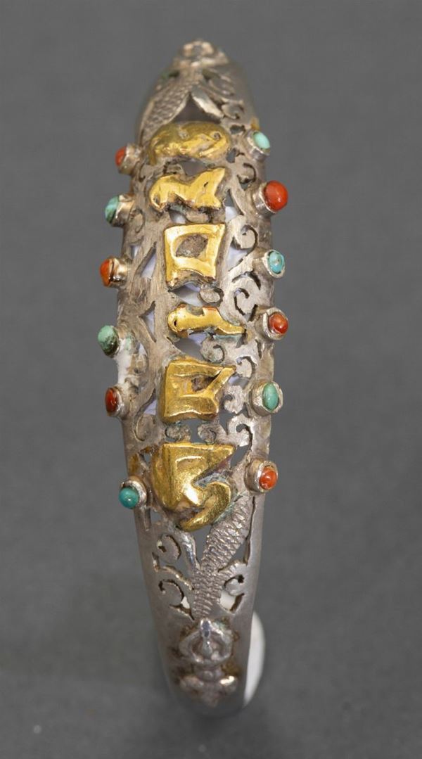 Bracciale rigido in argento e oro con decori a traforo e inserti in pietre dure, Tibet, inizio XX secolo