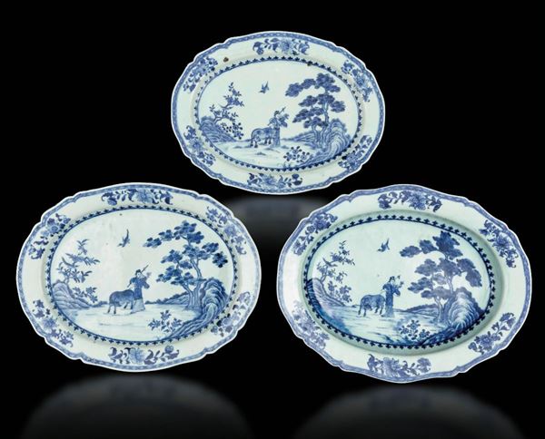 Tre piatti ovali in porcellana bianca e blu con figura di contadino entro paesaggio e decori floreali, Cina, Dinastia Qing, epoca Qianlong (1736-1796)
