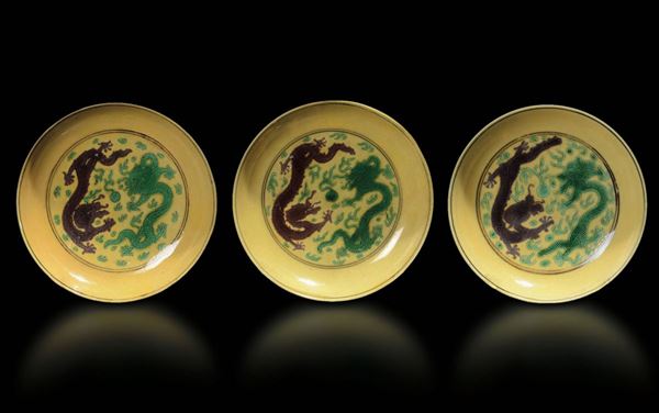 Tre piccoli piatti in porcellana a smalti Sancai con decoro di draghi tra le nuvole, Cina, Dinastia Qing, marchio e del periodo Qianlong (1736-1796)