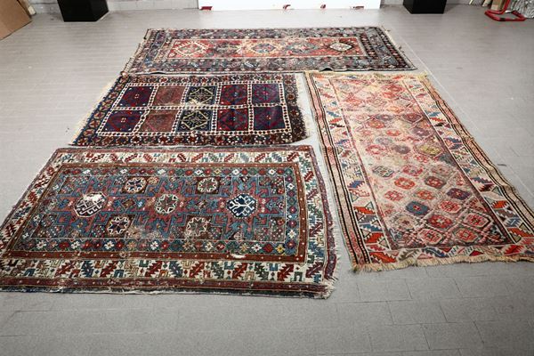 Lotto di quattro tappeti tre caucasici ed uno persiano fine XIX inizio XX secolo
