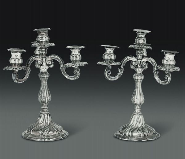 Coppia di candelabri a quattro luci in argento fuso e cesellato. Manifattura artistica italiana del XX secolo