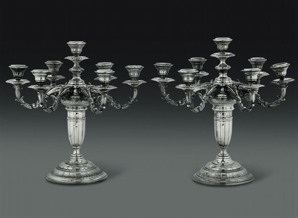 Coppia di candelabri a sette fiamme in argento fuso e cesellato. Manifattura artistica del XX secolo (marchi non identificati)