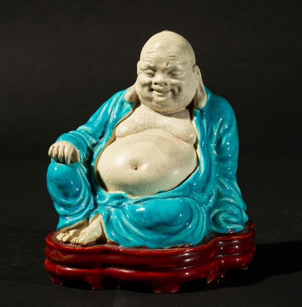 Piccola figura di Budai seduto con veste azzurra in porcellana smaltata, Cina, XIX secolo