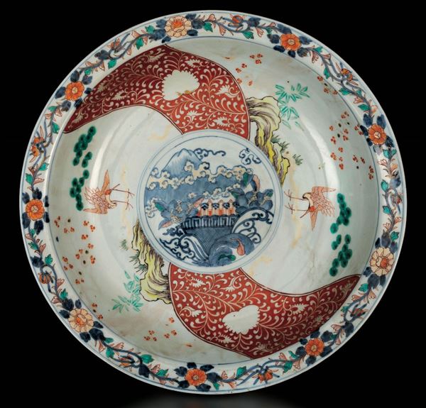 Grande piatto in porcellana Arita con decoro floreale e soggetti naturalistici entro riserve, Giappone, periodo Meiji (1868-1912)