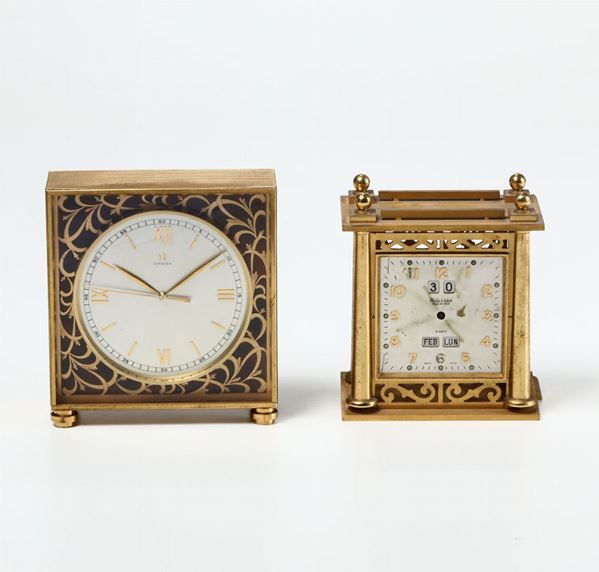 Due pendolette da tavolo in ottone dorato Omega e Philip Watch, XX secolo