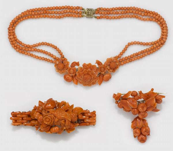 Lotto gioielli in corallo inciso, composto da un bracciale, una collana ed una spilla