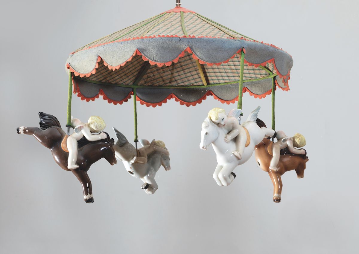 Lenci, Lampadario a giostra in pannolenci con putti alati a cavallo e elementi in ceramica a cola...
