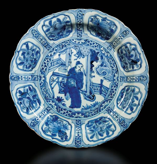 Piatto in porcellana bianca e blu con figura di saggio centrale e decori naturalistici entro riserve, Cina, Dinastia Ming, epoca Wanli (1573-1619)