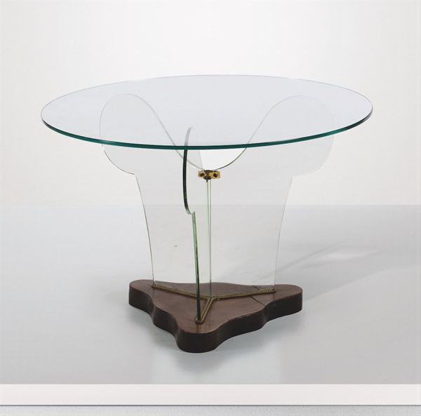 Tavolo basso con struttura in vetro molato e base in legno. Dettagli in ottone.