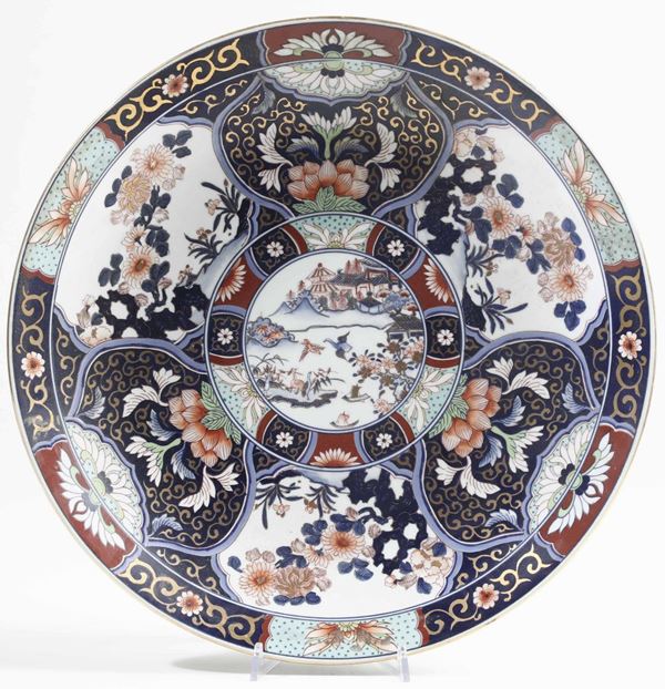 Piatto in porcellana Imari con decori floreali e soggetti naturalistici entro riserve, Giappone, periodo Meiji (1868-1912)