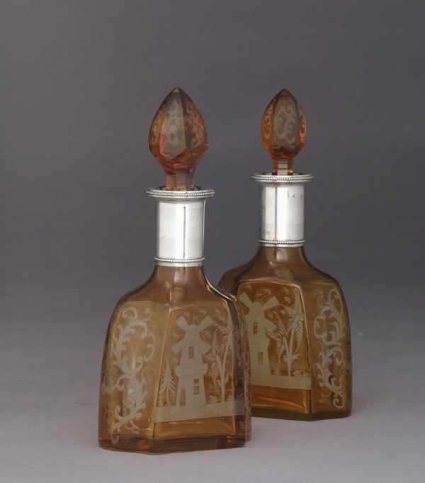 Coppia di bottiglie in vetro inciso e finimenti in argento. Argenteria del XX secolo