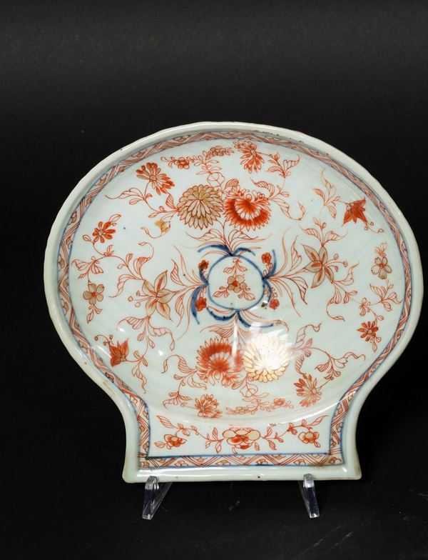 Piccolo piatto a foggia di conchiglia in porcellana Imari con decori floreali, Cina, Dinastia Qing, epoca Kangxi (1662-1722)