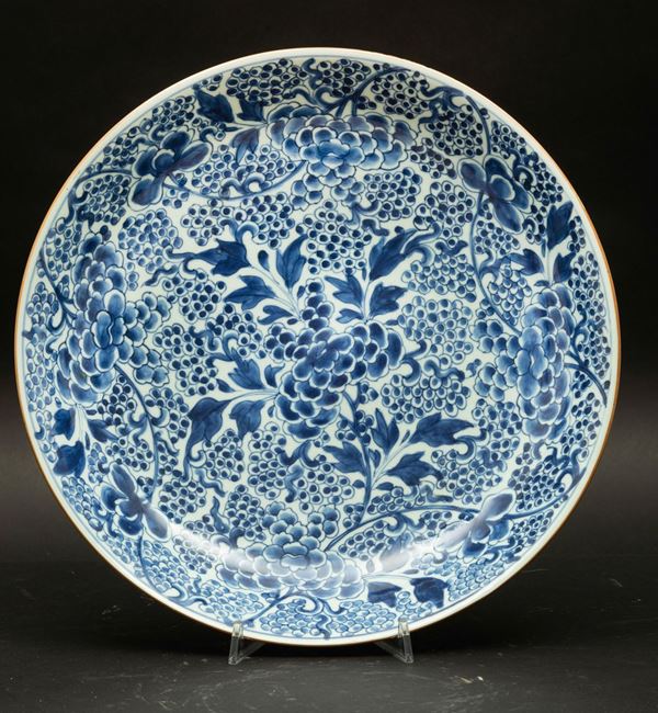 Grande piatto in porcellana bianca e blu con decori vegetali, Cina, Dinastia Qing, epoca Kangxi (1662-1722)