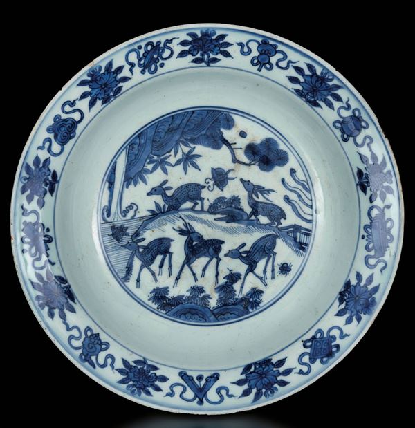 Grande piatto in porcellana bianca e blu con cerbiatti entro paesaggio e simboli buddhisti, Cina, Dinastia Ming, epoca Wanli (1573-1619)