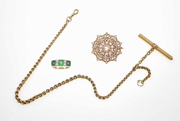 Lotto composto da una catena da orologio, un anello con smeraldi e diamanti ed una spilla