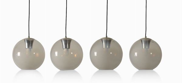 Quattro lampade a sospensione con struttura in metallo e diffusore in vetro parzialmente opalino.