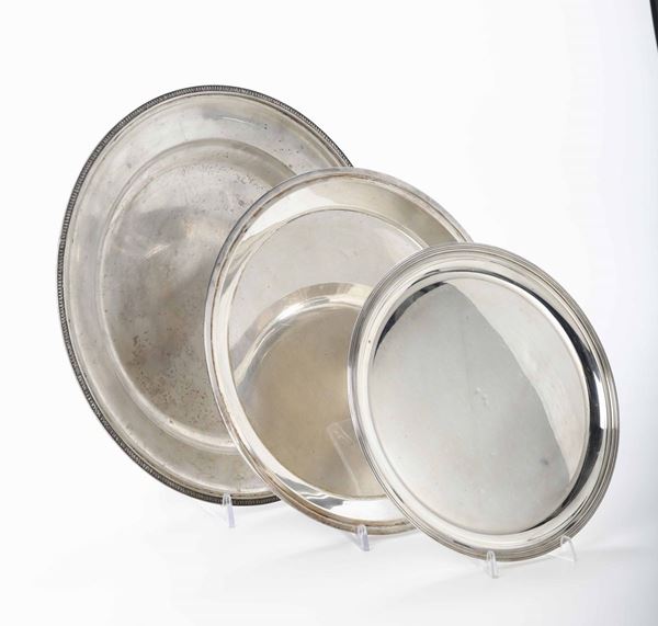 Tre piatti in argento di forma circolare con bordo nervato. Italia XX secolo