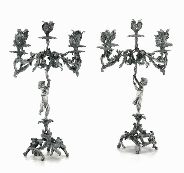 Coppia di candelabri in argento fuso e cesellato. Argenteria artistica italiana del XX secolo
