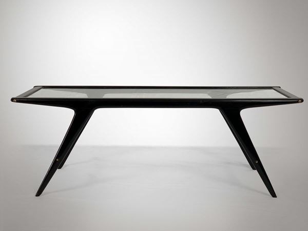 Tavolo basso con struttura in legno, piano in cristallo e particolari in ottone.