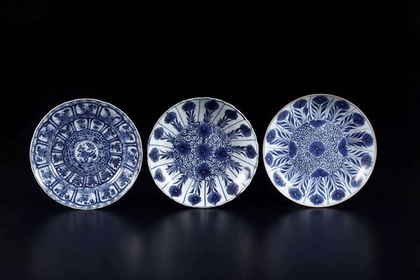 Tre piatti diversi in porcellana bianca e blu con decori naturalistici e floreali, Cina, Dinastia Qing, epoca Kangxi (1662-1722)